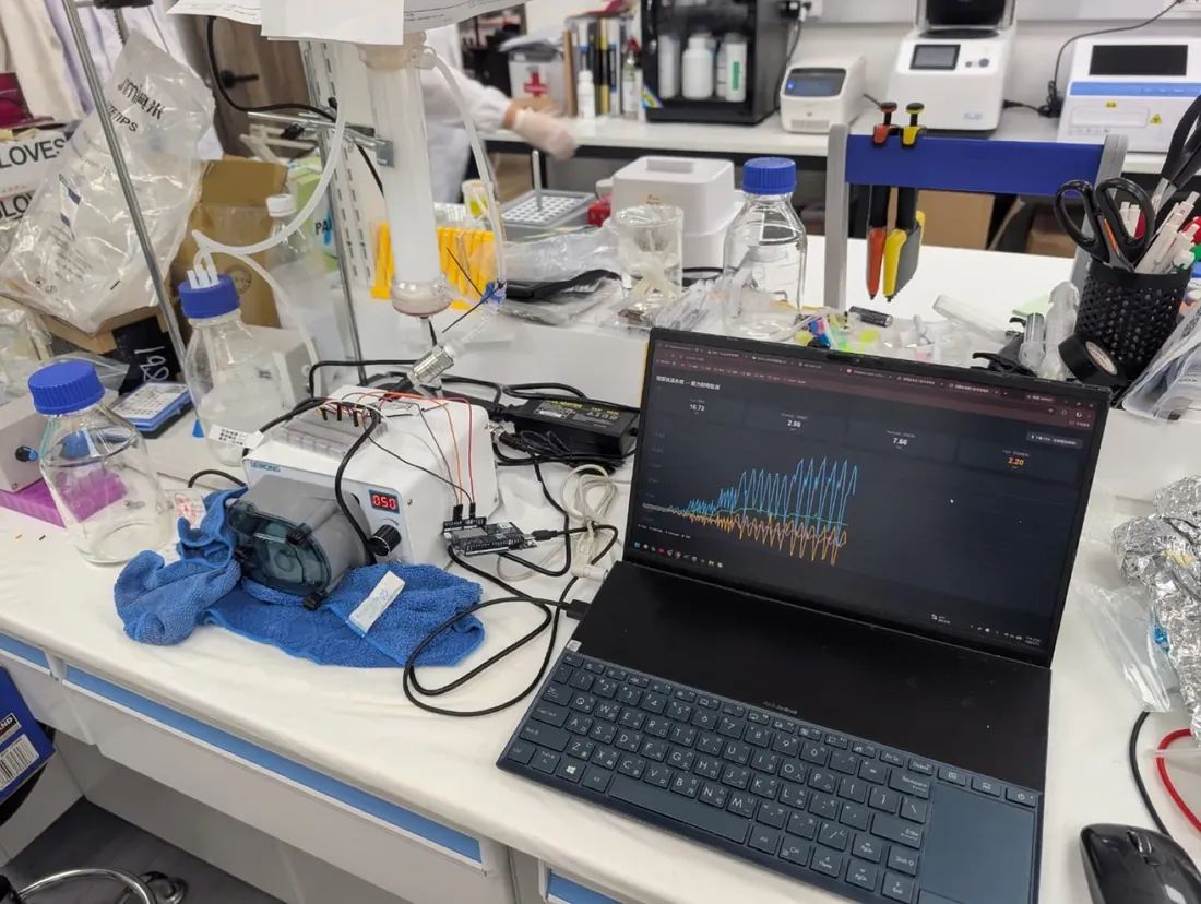 The redesigned loop on a crowded bench, a laptop beside it plotting live sensor data.