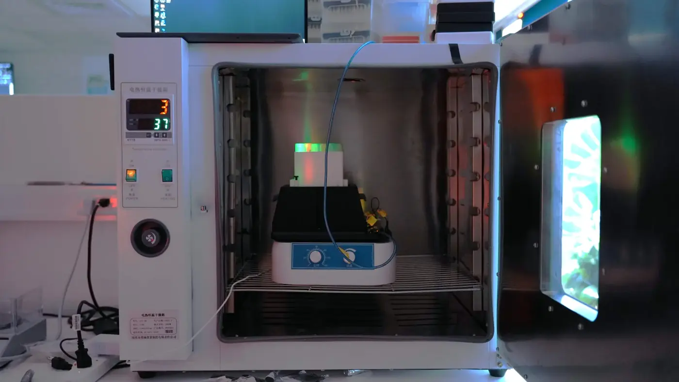LPA sitting on a shaker inside an open incubator, its LEDs lit green.