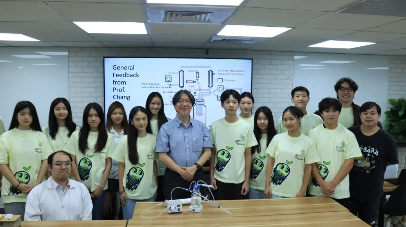 The team in matching shirts stands with a professor in front of a slide headed General Feedback.
