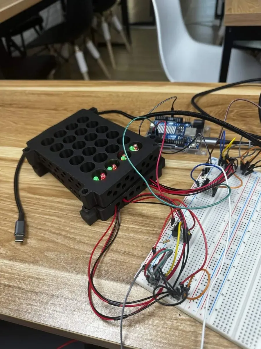 The first LPA: a black block with a grid of holes, a few LEDs lit, wired to a breadboard.