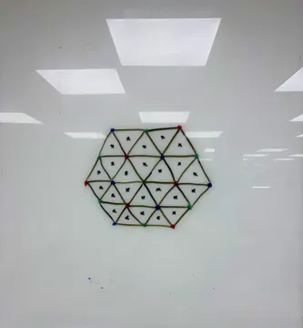 A hexagon of triangles drawn on a whiteboard, with coloured dots at the corners and a cross marking the centre of each triangle.