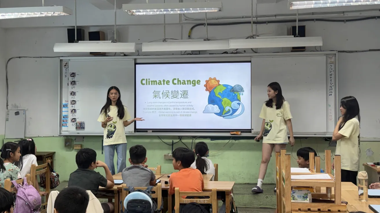 Team members presenting a Climate Change vocabulary slide to a class of elementary students.
