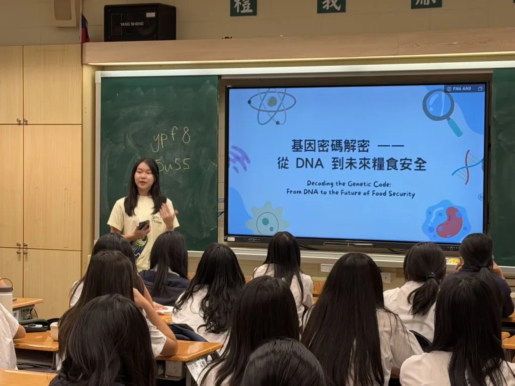 A team member beside the title slide of the lesson, Decoding the Genetic Code: From DNA to the Future of Food Security, in Chinese and English.