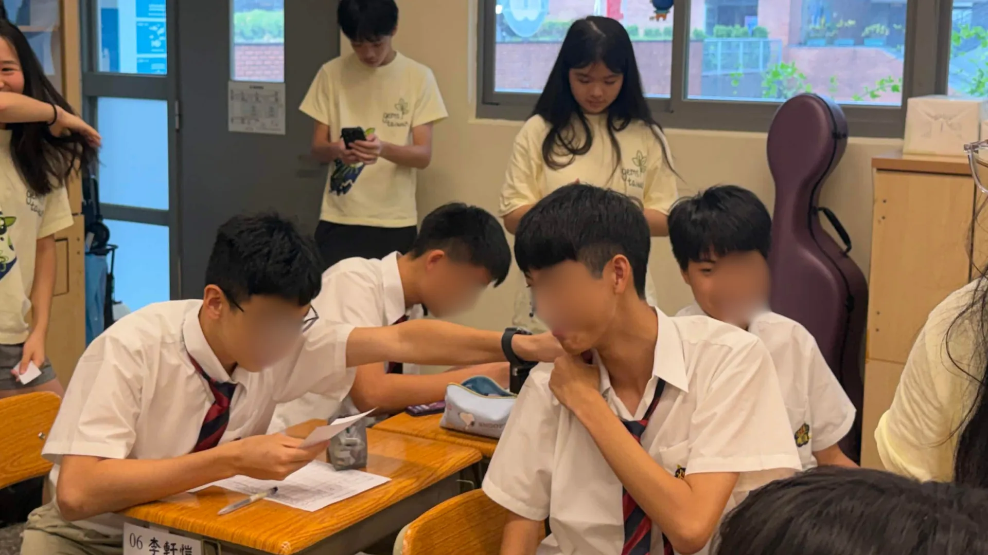 High school students at their desks passing written sequences to each other during the mutation relay game.