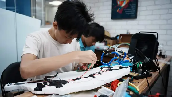 A student assembling a stress map of Taiwan on a table.