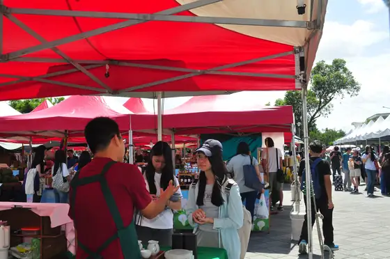 A student interviewing a stallholder at the market.