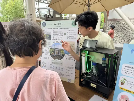 A student explaining the bioreactor poster to a visitor.