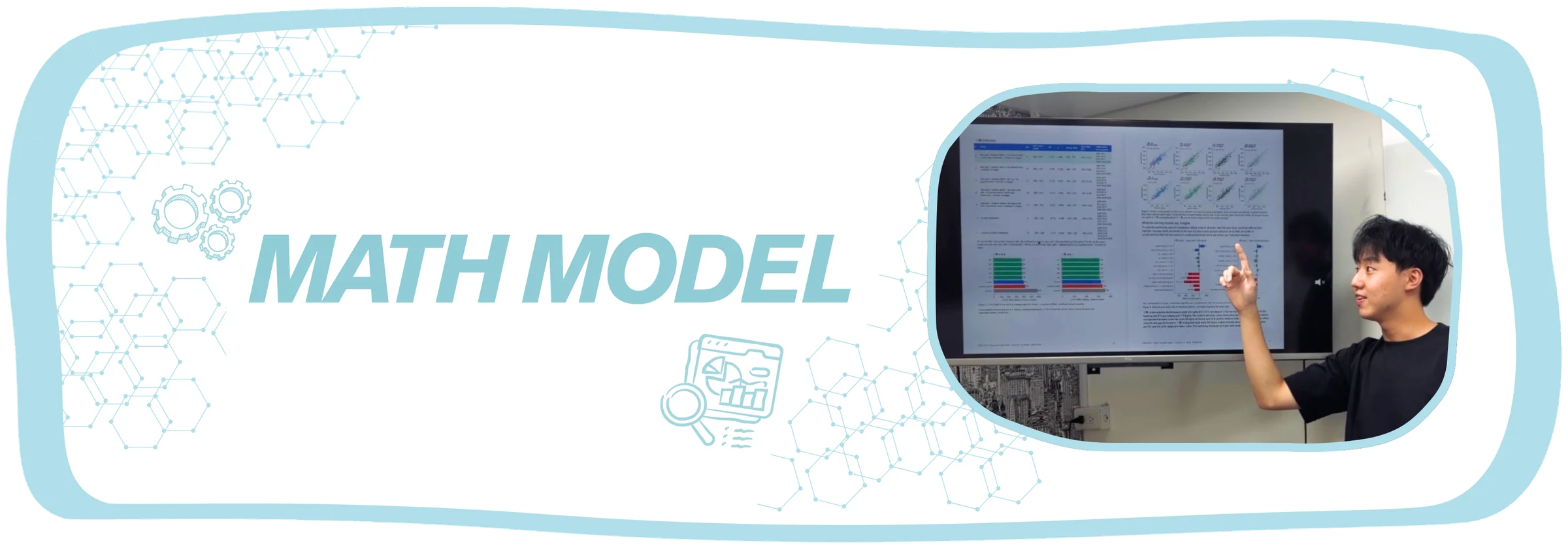 Math Model. A team member points at a screen of model fits and bar charts during a presentation.