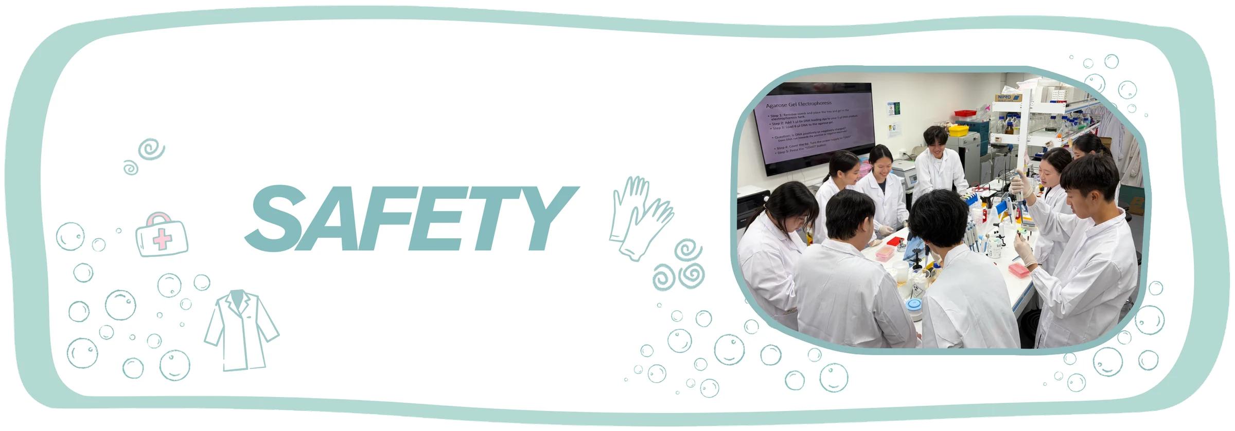 Safety and Security. A dozen students in white lab coats work around a shared bench under a projected agarose gel electrophoresis protocol.