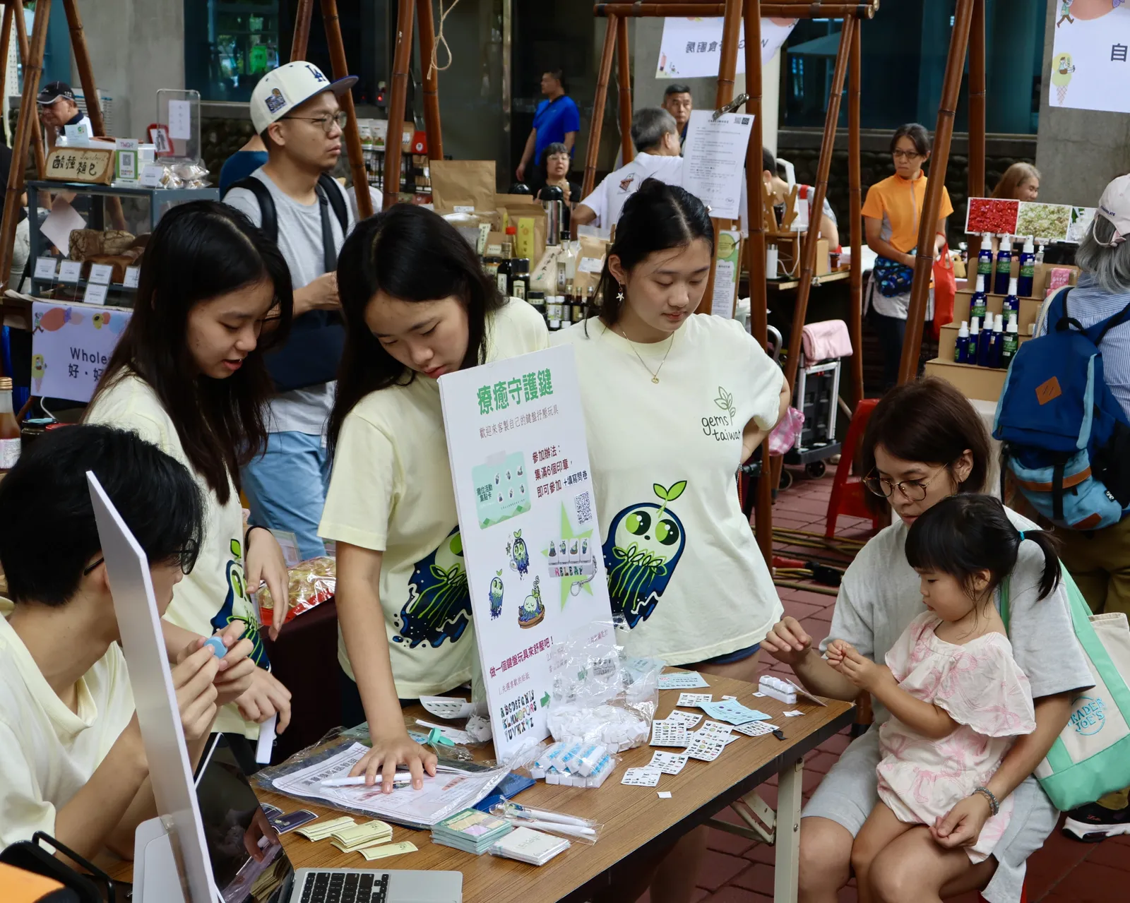 A child and a student at the crafts table.