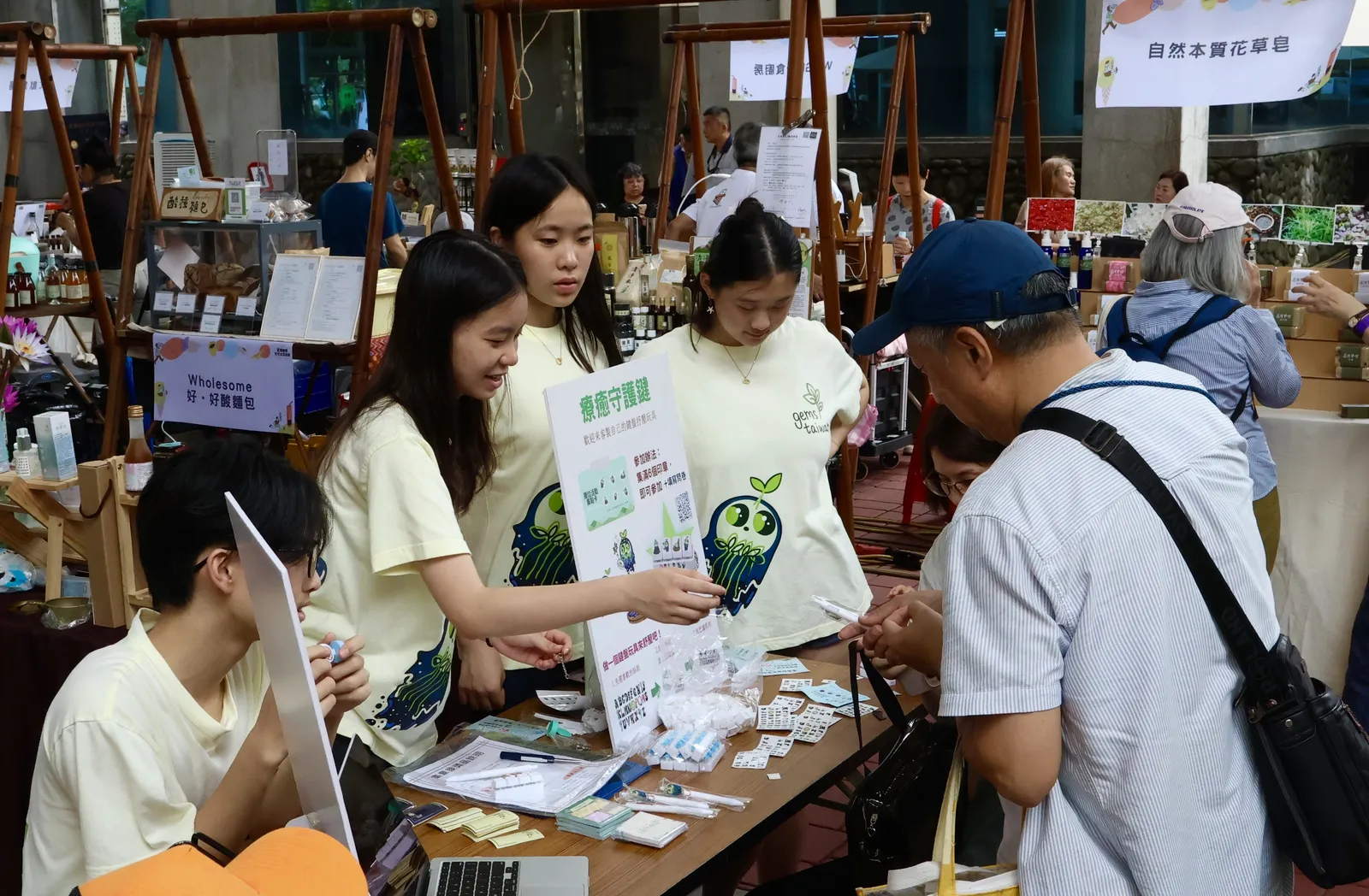 Students and children around a table of craft materials.