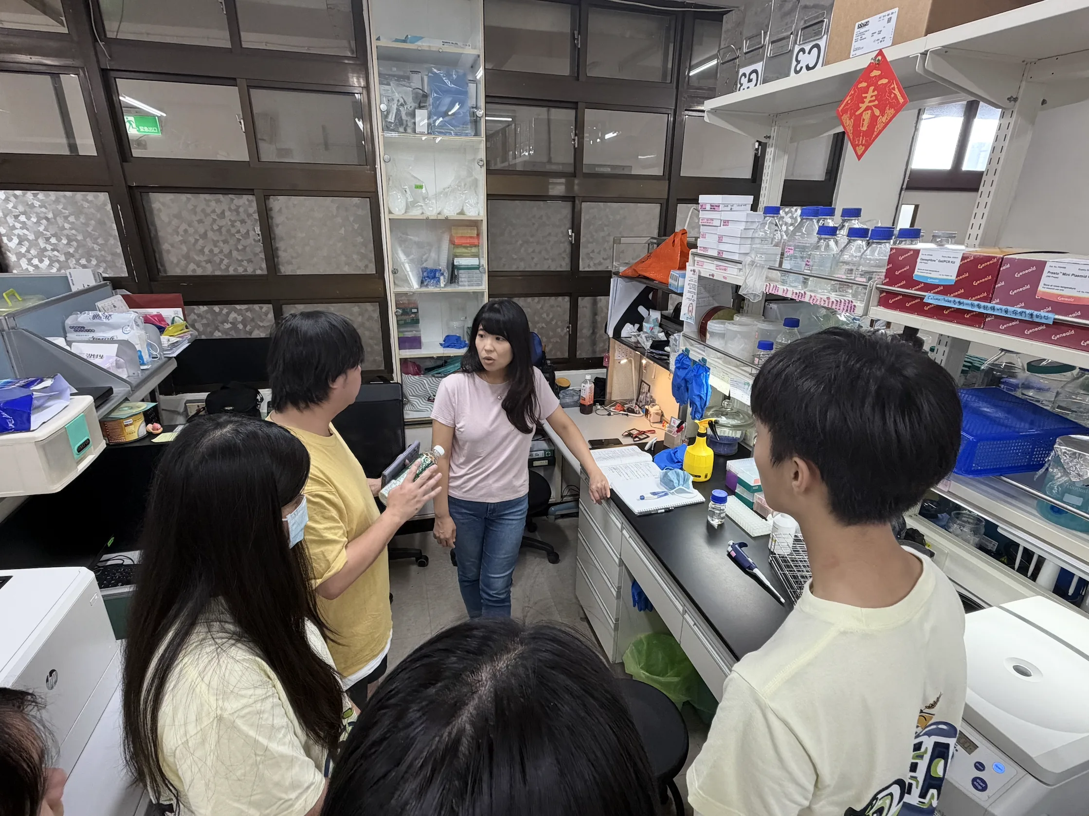 Prof. Cheng talking with students in her laboratory.
