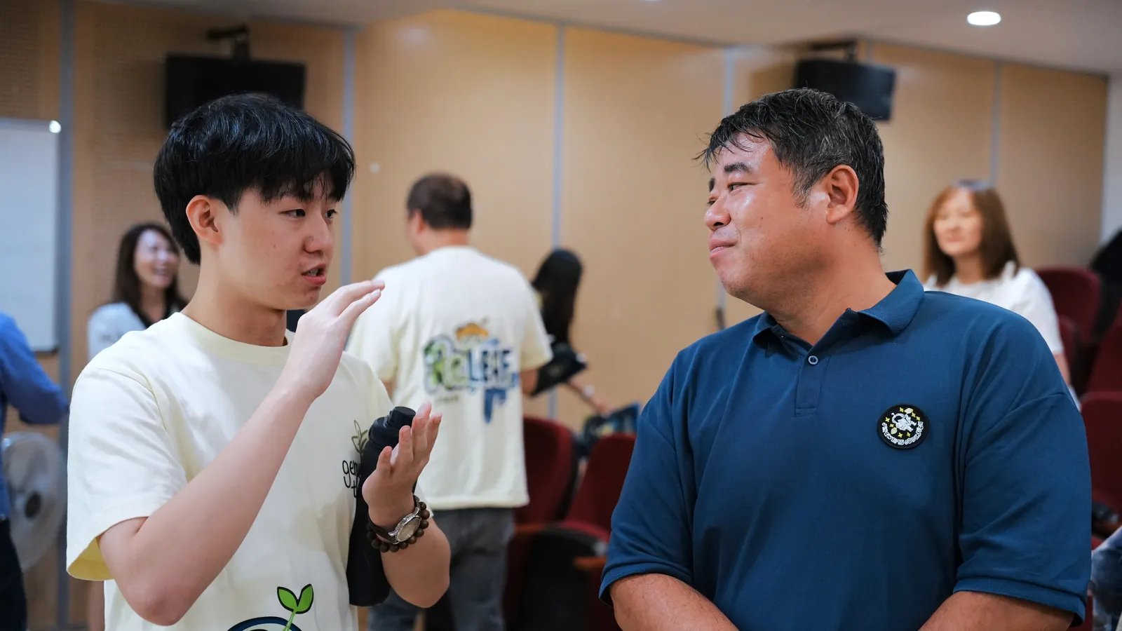 A student talking with a farmer in a navy shirt after the session.