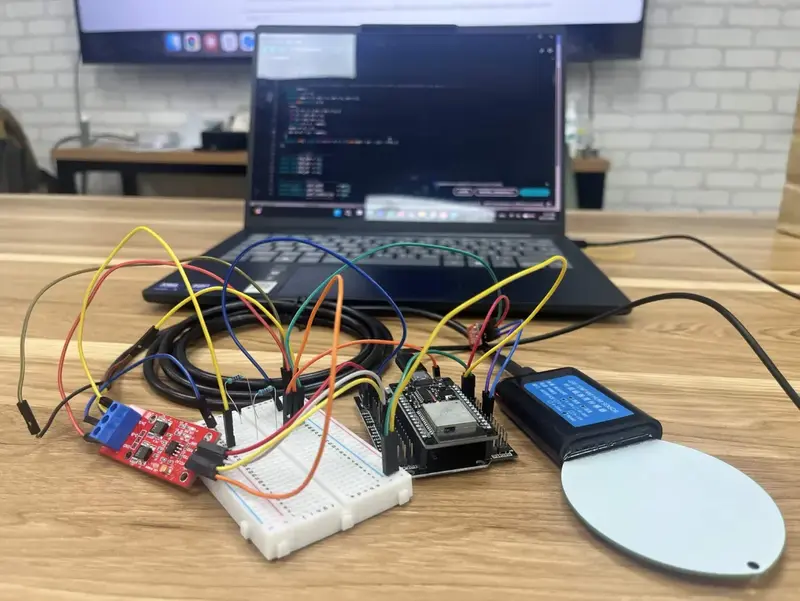 The bench rig on a desk: a breadboard carrying the SHT31, an ESP32 on its expansion board, a red RS485 converter, and the white disc of the leaf sensor on its cable.