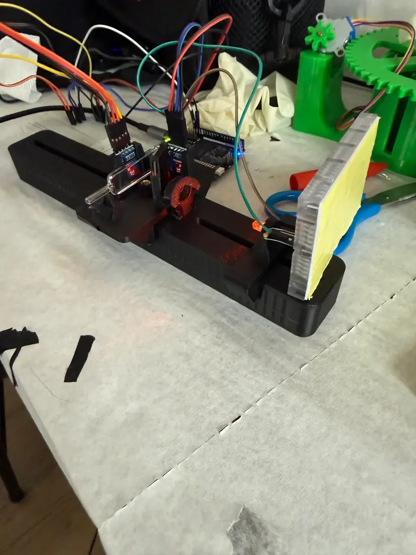 The first printed photometer: a black rail with its sliding mounts and the sensor end, wired to a breadboard