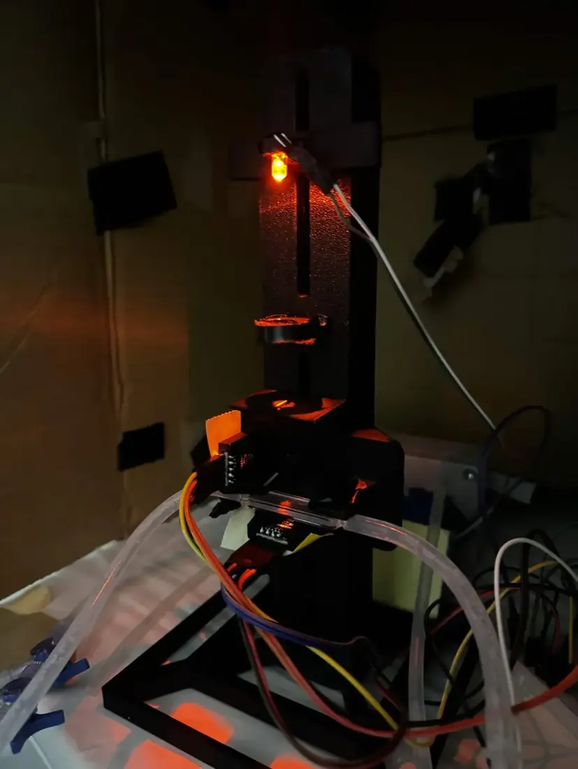 V2, the vertical photometer, standing upright on its base plate, the amber LED lit at the top