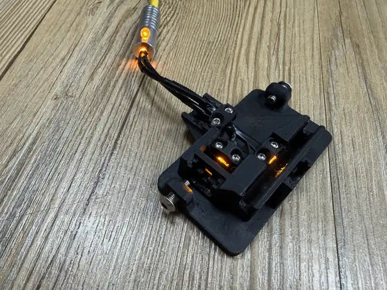 The open Slim photometer from above: clips screwed over the fibers, the amber light glowing in the sample and reference paths