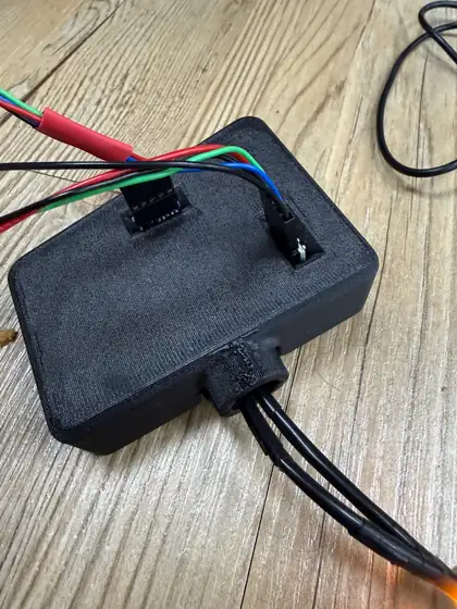 The Slim photometer with its case closed: a low black box with the sensor headers and wires coming up through its top