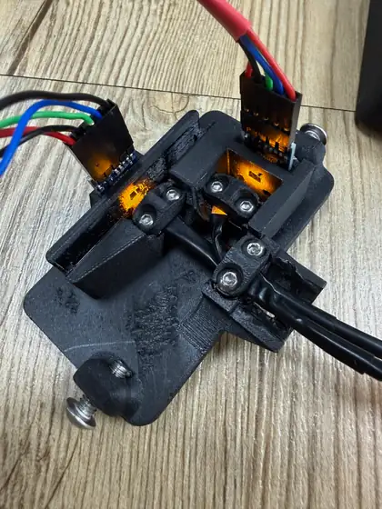 Close-up of the open Slim photometer: the two sensor boards wired with colored leads, the amber light in both windows