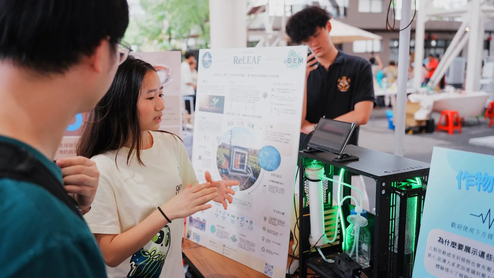 A student explains a poster to a visitor.