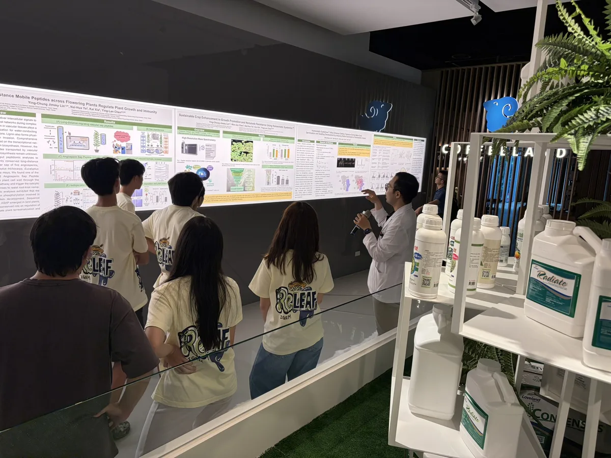 Students looking at a wall of research posters beside shelves of product bottles at CH Biotech.