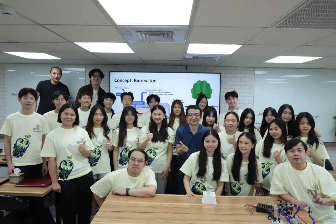 The team with Prof. Chen in a classroom, a slide titled Concept: Bioreactor on the screen behind them.