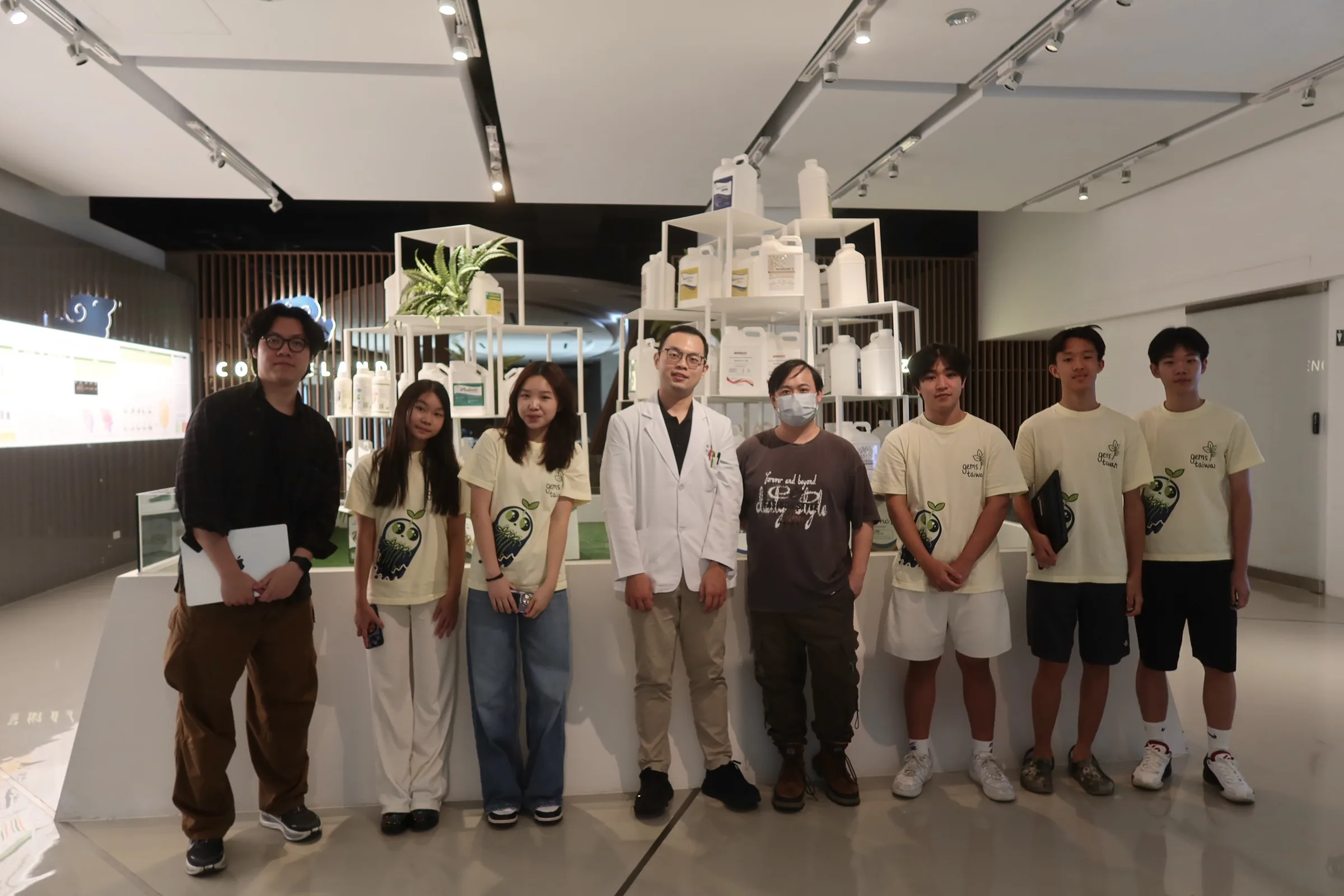 The team with two CH Biotech staff in front of a display of product bottles.
