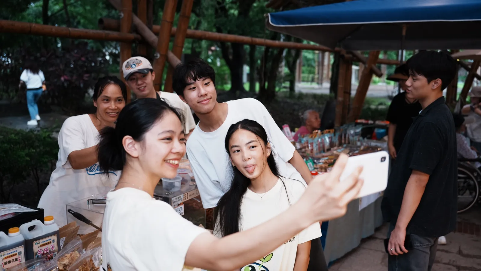 Students taking a photograph with a stallholder.