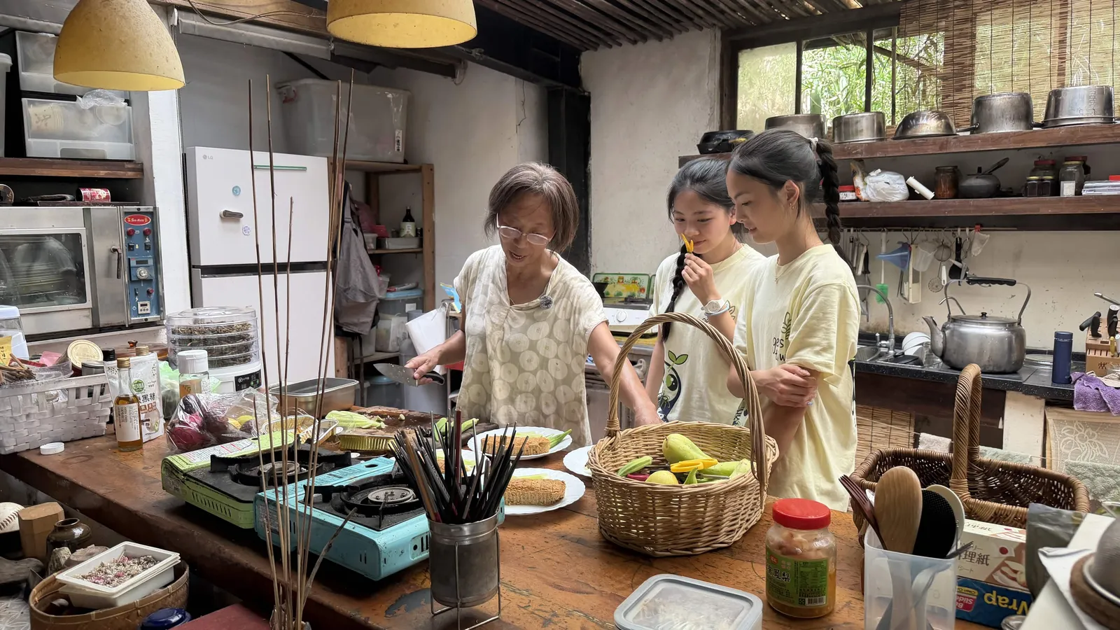 Ms. Chen cooking in her farm kitchen while students watch.