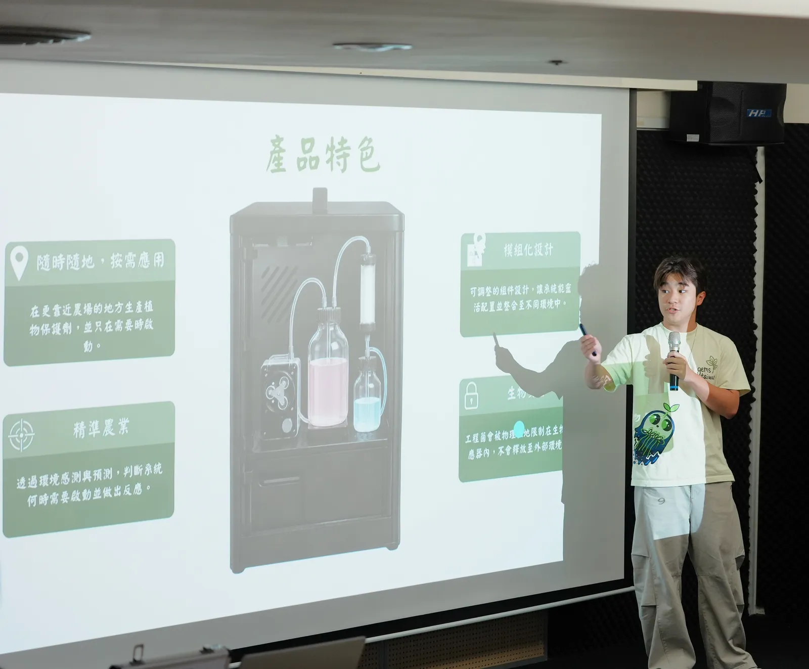 A student pointing to a projected slide showing the bioreactor and its features.